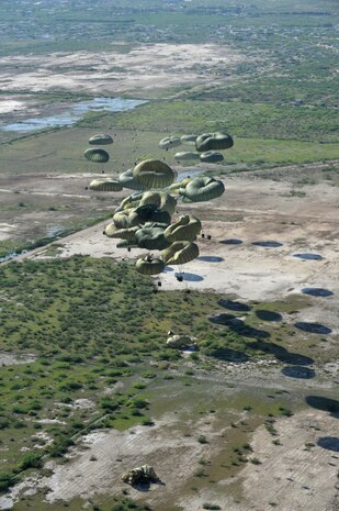 Forty pallets of relief supplies exit a C-17 Globemaster III cargo aircraft over Haiti Jan. 18, 2010. The C-17, crewed by Airmen from the 437th Airlift Wing at Charleston Air Force Base, S.C., departed Pope AFB, N.C., and delivered 40 pallets of food and water into Haiti. Joint Task Force-Haiti secured an area in which to air deliver the supplies. Once on the ground, supplies were distributed by JTF-Haiti, the U.S. Agency for International Development and other relief personnel.(U.S. Air Force photo by Master Sgt. Shane A. Cuomo/Released)
