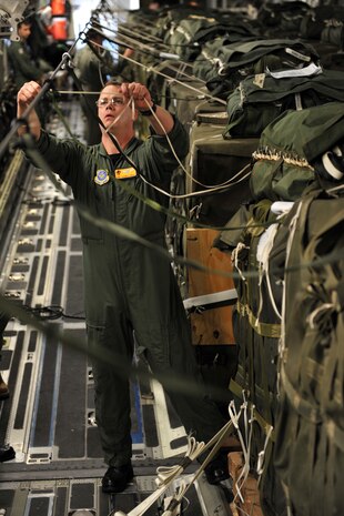 Tech. Sgt. Aaron Avery attaches de-oscillation ties to pallets of relief supplies aboard a C-17 Globemaster III cargo aircraft Jan. 18, 2010, at Pope Air Force Base in Fayetteville, N.C., before it takes off for a humanitarian mission to Haiti. Avery is a loadmaster from the 16th Airlift Squadron, Charleston Air Force Base, Charleston, S.C. The C-17 conducted the first humanitarian air delivery mission over Haiti. U.S. Southern Command is deploying assets to Haiti to conduct search and rescue operations, damage assessments and sustained humanitarian assistance and disaster relief operations. (U.S. Air Force photo by Master Sgt. Shane A. Cuomo/Released)