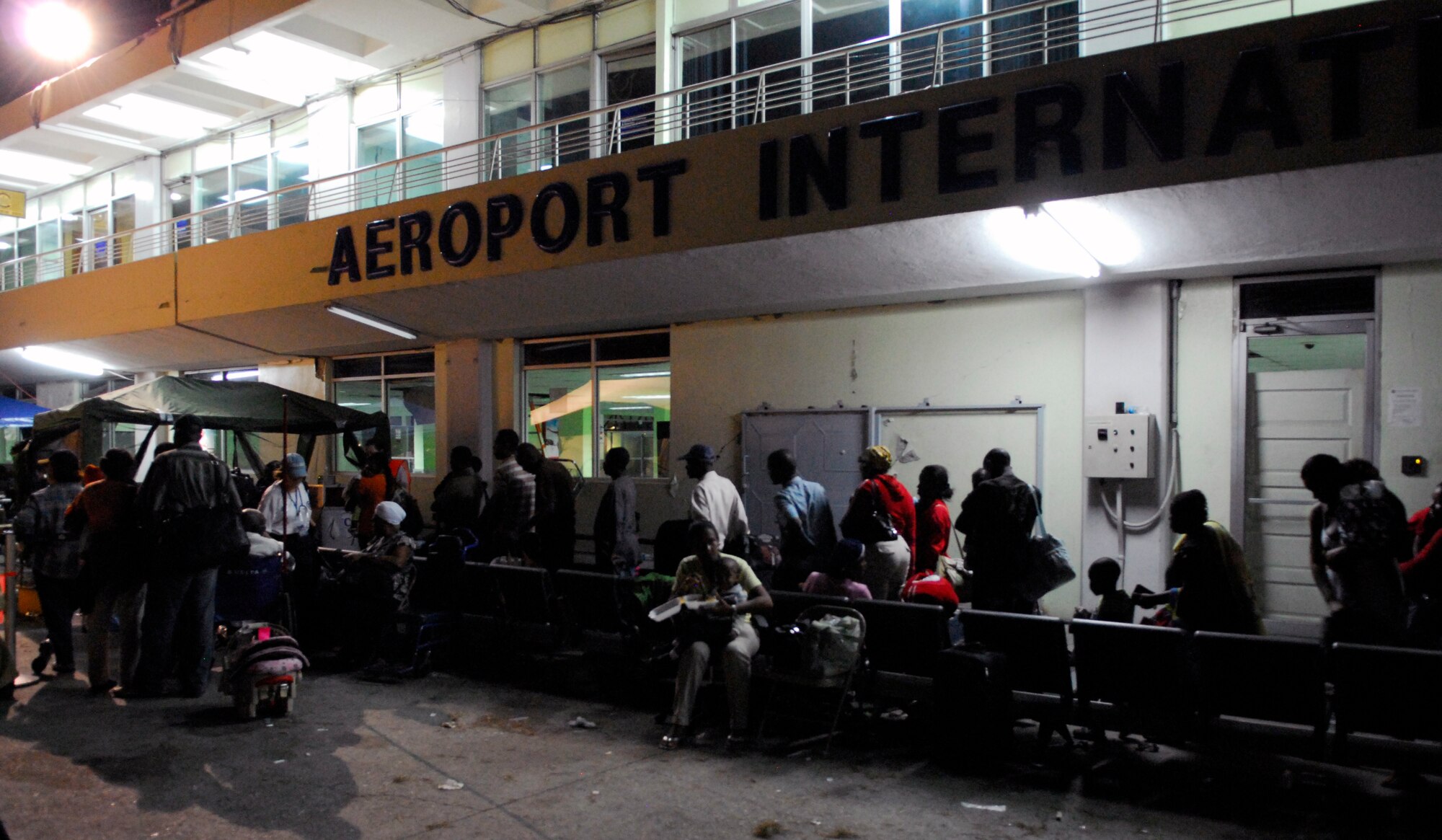 A line of American citizens await clearance from the U.S. State Department to board awaiting Air Force aircraft on the ramp at the Toussaint Louverture International Airport in Port-au-Prince, Haiti, Jan. 19.  The State Department provided passage for displaced U.S. citizens to Orlando International Airport in Florida.  (U.S. Air Force photo/1st Lt. Matt Schroff)