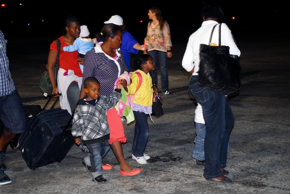 American citizens displaced by the recent earthquake walk towards a waiting C-17 cargo aircraft for transport out of Port-au-Prince, Haiti, Jan. 19.  The same C-17 that delivered supplies from Pope Air Force Base, North Carolina, to Haiti completed the return trip with a brief stop in Florida to deliver passengers.  (U.S. Air Force photo/1st Lt. Matt Schroff) 