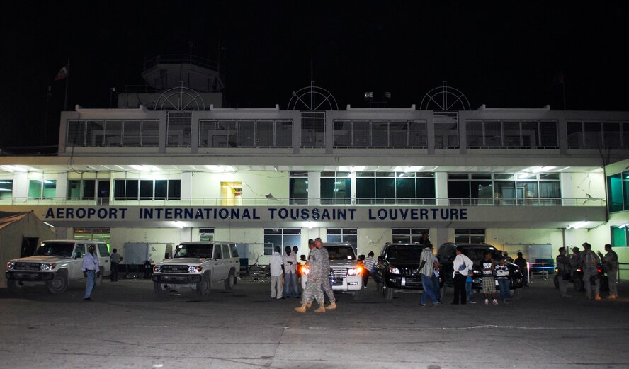 The cracked walls of the Toussaint Louverture International Airport serve as a backdrop for military personnel providing security and civilians awaiting evacuation in Port-au-Prince, Haiti, Jan. 19.  Airmen helped the Haiti government bring the airport back up to operational status within 24 hours of the earthquake, and continue to help manage air traffic control.  (U.S. Air Force photo/1st Lt. Matt Schroff)