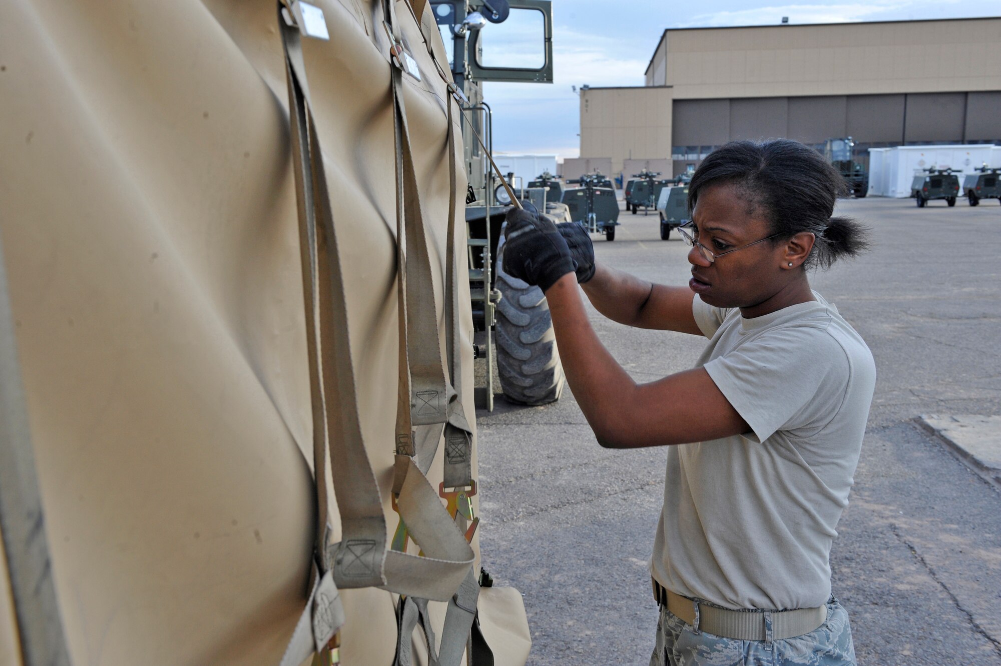 Senior Airman Breanna Fuller straps down a 1500 reverse osmosis water purification unit, or ROWPU, preparing it for transportation, Jan. 17, 2010, at Holloman Air Force Base, N.M. The base is preparing tents, generators, air conditioning units, ROWPUs and personnel to send to Haiti after that country was rocked by a magnitude 7 earthquake Jan. 12, leaving thousands dead and even more homeless. Airman Fuller is from the 49th Materiel Maintenance Group. (U.S. Air Force photo/Staff Sgt. Anthony Nelson)