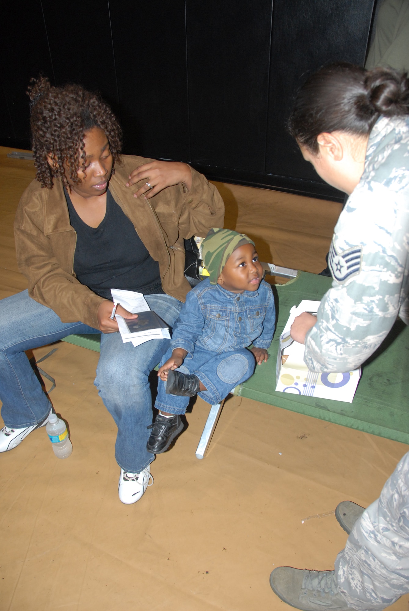 An Air Force reservist from the 482nd Fighter Wing at Homestead Air Reserve Base, Fla., gives some food and a smile to a young boy who arrived from Haiti Jan. 20. 2010. The boy and his family are being in-processed on base. Hundreds of evacuees have been in-processed so far and thousands more are expected. (Air Force photo/Master Sgt. Chance Babin)