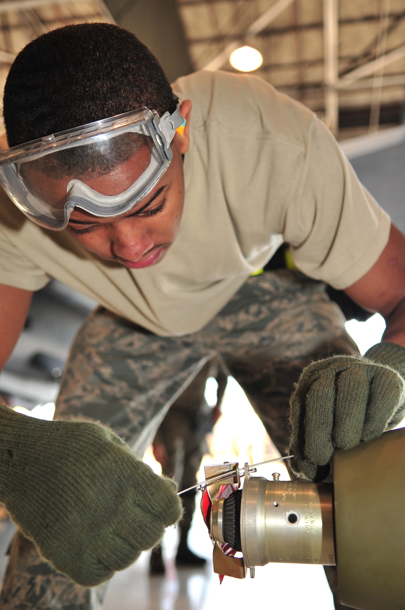 Airman 1st Class Mario McNair, 336th Aircraft Maintenance Unit load crew member, wires a fuse for a Mark-82 low-drag munition during the load crew competition on Seymour Johnson Air Force Base, N.C., Jan. 15, 2010. Load crews are tested on their ability to perform weapons loading tasks quickly and correctly. McNair hails from Glascock, Ga. (U.S. Air Force photo/Airman 1st Class Rae Perry) 
