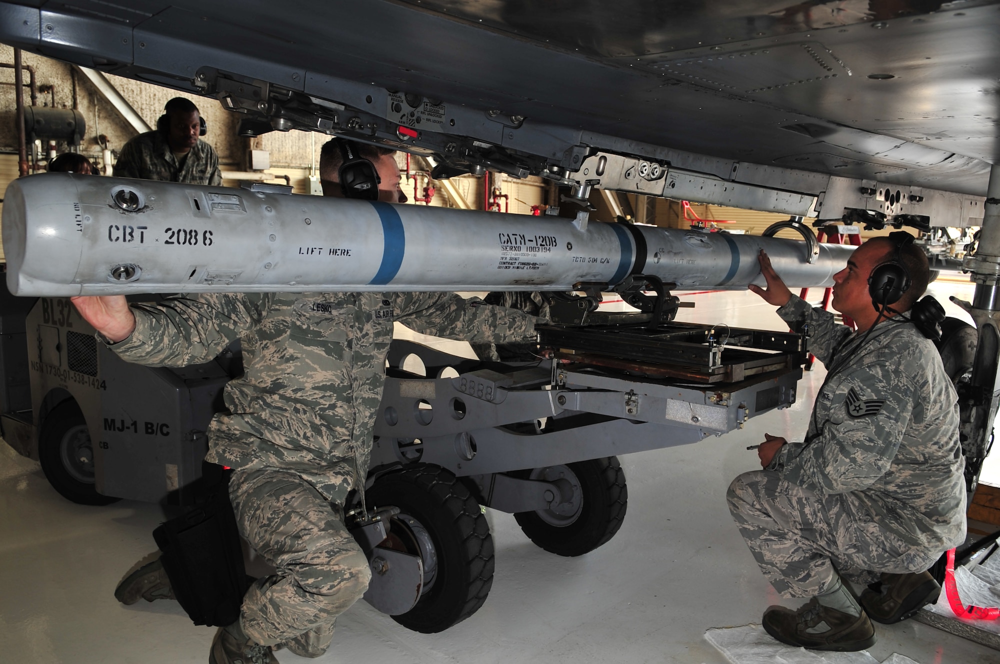 Airmen from the 333rd Aircraft Maintenance Unit load an AIM-120 munition onto an F-15E Strike Eagle during a weapons load crew competition on Seymour Johnson Air Force Base, N.C., Jan. 15, 2010.  Airmen loaded three different types of weapons onto the Strike Eagle, the team that completes their tasks with the least amount of errors in the quickest time will be victorious. (U.S. Air Force photo/Airman 1st Class Rae Perry)