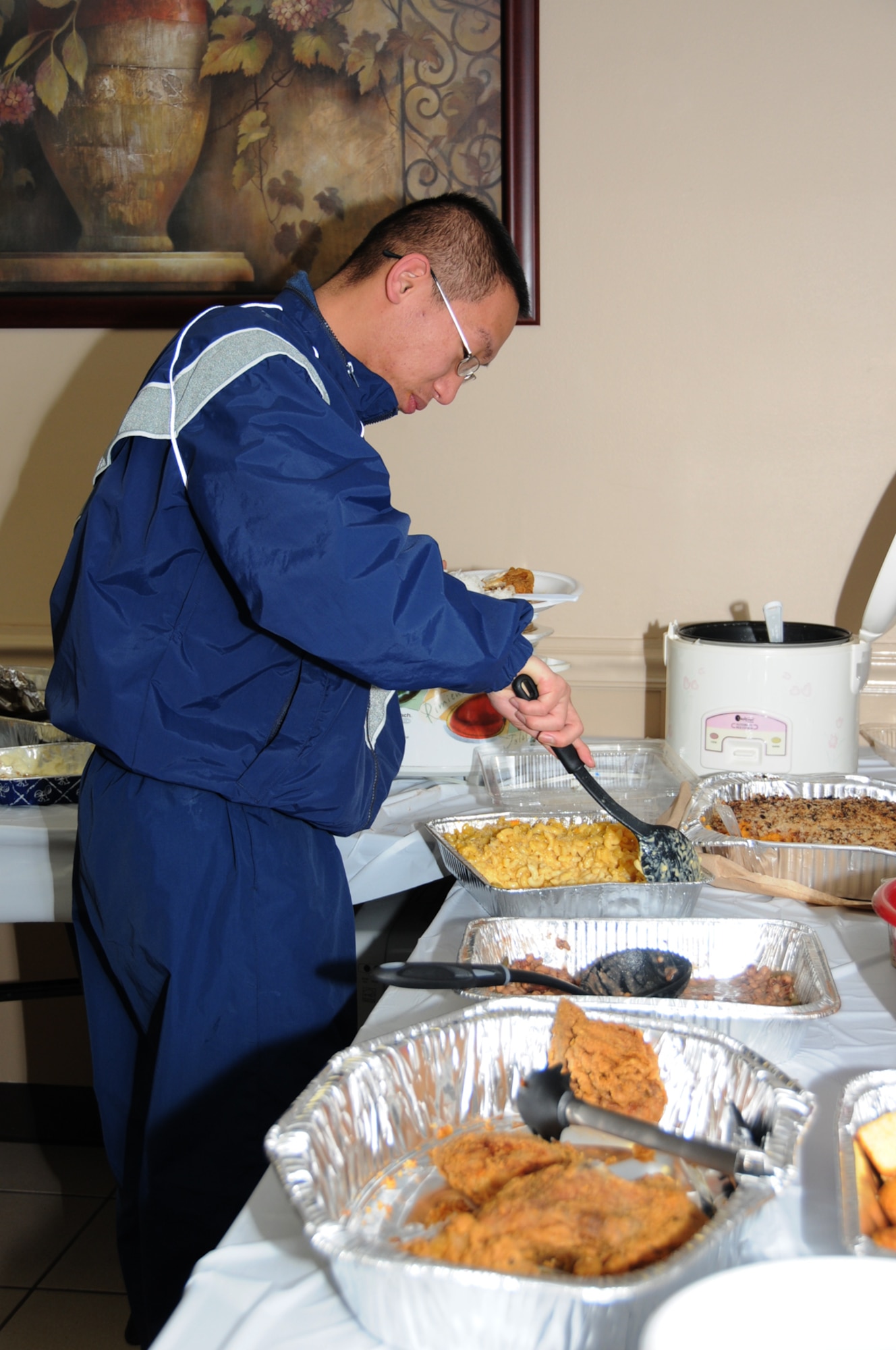 Airman 1st Class Randy Tuazon, 81st Medical Operations Squadron, helps himself to homemade macaroni and cheese at a soul food dinner  at The Haven Sunday.  The food was supplied by the 81st Training Wing command staff and the chapel.  Chaplain (Col.) Richard Dunn, wing chaplain, said the chapel has provided the weekly dinners for permanent party dormitory residents for nearly 18 months, and sometimes other organizations provide the meals.  If you’d like to volunteer to host one of the meals, call Chaplain (Lt. Col.) Francis Lowe, 377-2520.  (U.S. Air Force photo by Kemberly Groue)