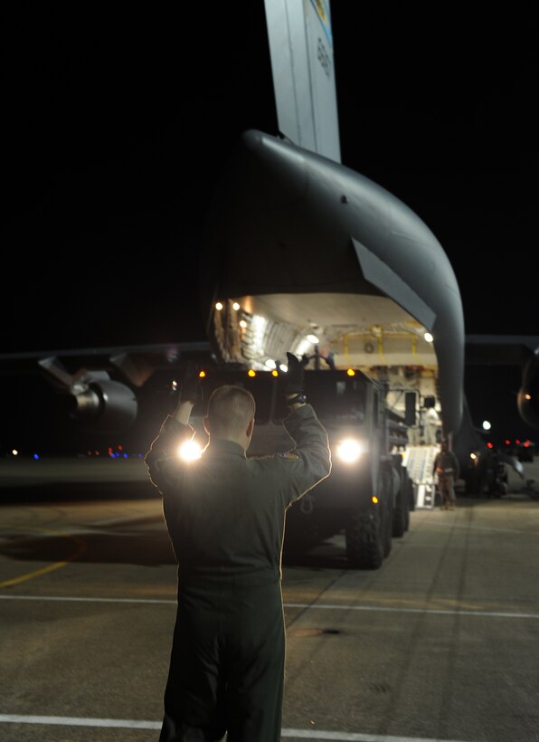 LANGLEY AIR FORCE BASE, Va. -- A loadmaster from 436th Airlift Wing, Dover Air Force Base, Del., directs an M1120 Heavy Expanded Mobility Tactical Truck Load Handling System into a C-17 Globemaster III Jan. 19.  Personnel from Langley and U.S. Army Fort Eustis worked together to load the C-17 as part Operation Unified Response to aid Haiti after the earthquakes. (U.S. Air Force photo/Senior Airman Zachary Wolf)
