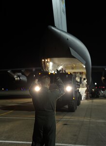 LANGLEY AIR FORCE BASE, Va. -- A loadmaster from 436th Airlift Wing, Dover Air Force Base, Del., directs an M1120 Heavy Expanded Mobility Tactical Truck Load Handling System into a C-17 Globemaster III Jan. 19.  Personnel from Langley and U.S. Army Fort Eustis worked together to load the C-17 as part Operation Unified Response to aid Haiti after the earthquakes. (U.S. Air Force photo/Senior Airman Zachary Wolf)
