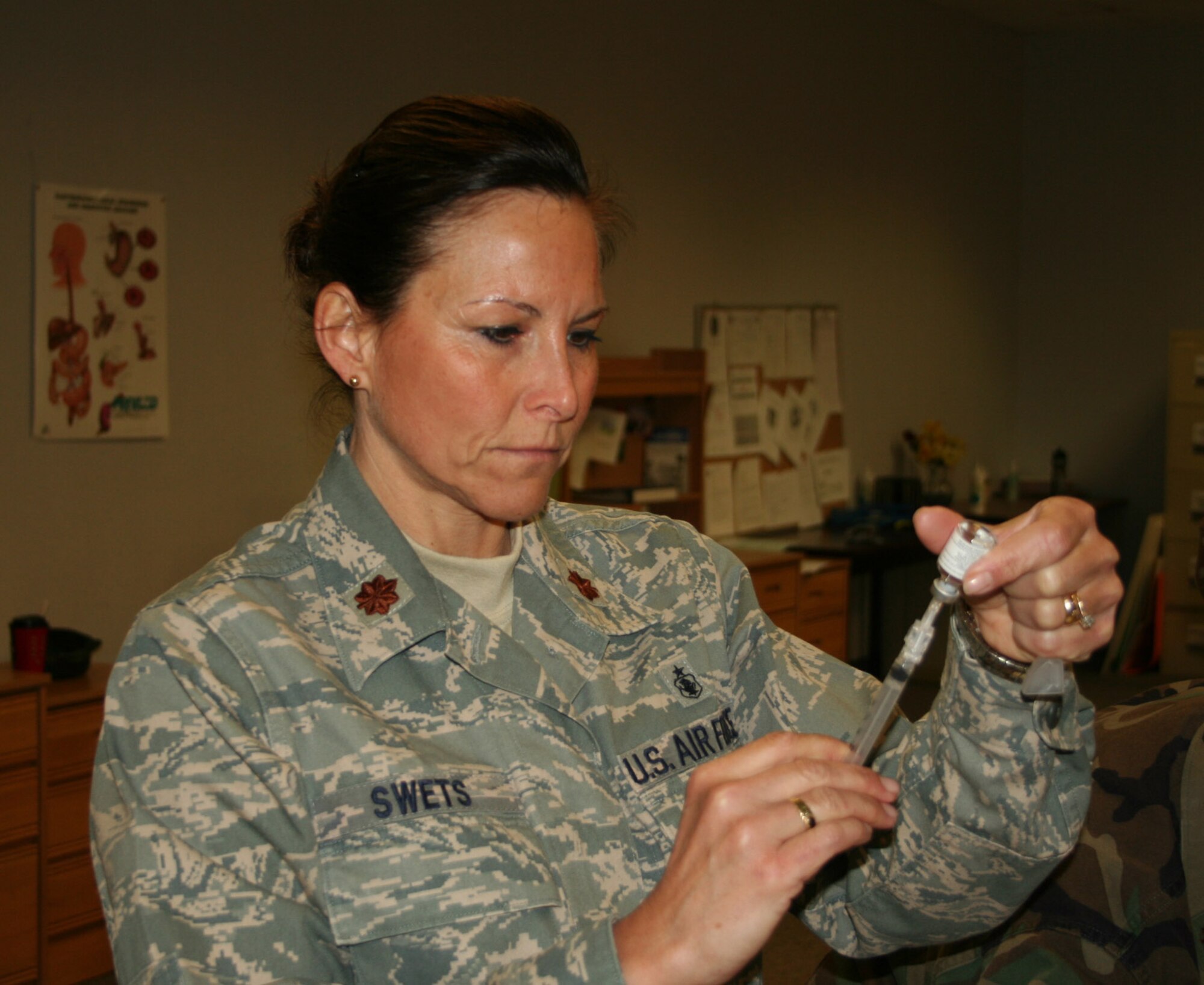 WRIGHT-PATTERSON AIR FORCE BASE, Ohio - Maj. Amy Swets, 445th Aeromedical Staging Squadron, prepares a syringe with the H1N1 vaccine during the Jan. 9 unit training assembly. Col. Stephen Goeman, 445th Airlift Wing, commander, was the first wing member to receive the shot here. The H1N1 vaccination is a new requirement for all reservists assigned to the wing.  (U.S. Air Force photo/Senior Airman Matthew Cook)