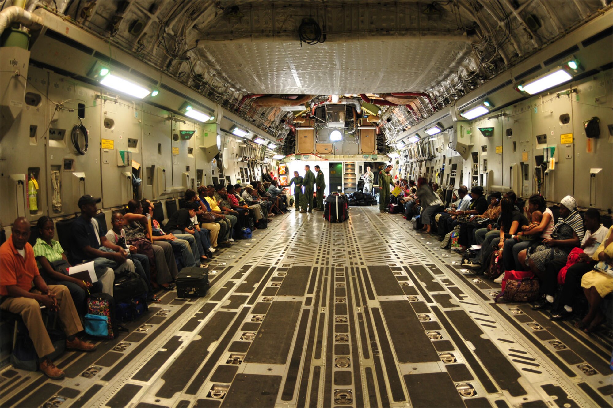 Port au Prince, Haiti – C-17 crew members from Altus AFB, Okla., help 54 Haitian evacuees get ready for takeoff from the Toussaint Louverture International Airport in Port au Prince, Haiti, Jan. 18. After the Altus C-17 Globemaster III offloaded all of its cargo at the airport, the earthquake victims were transported to the Orlando International Airport in Orlando, Fla., to meet connecting flights. (U.S. Air Force photo/Senior Airman Amanda Bower)