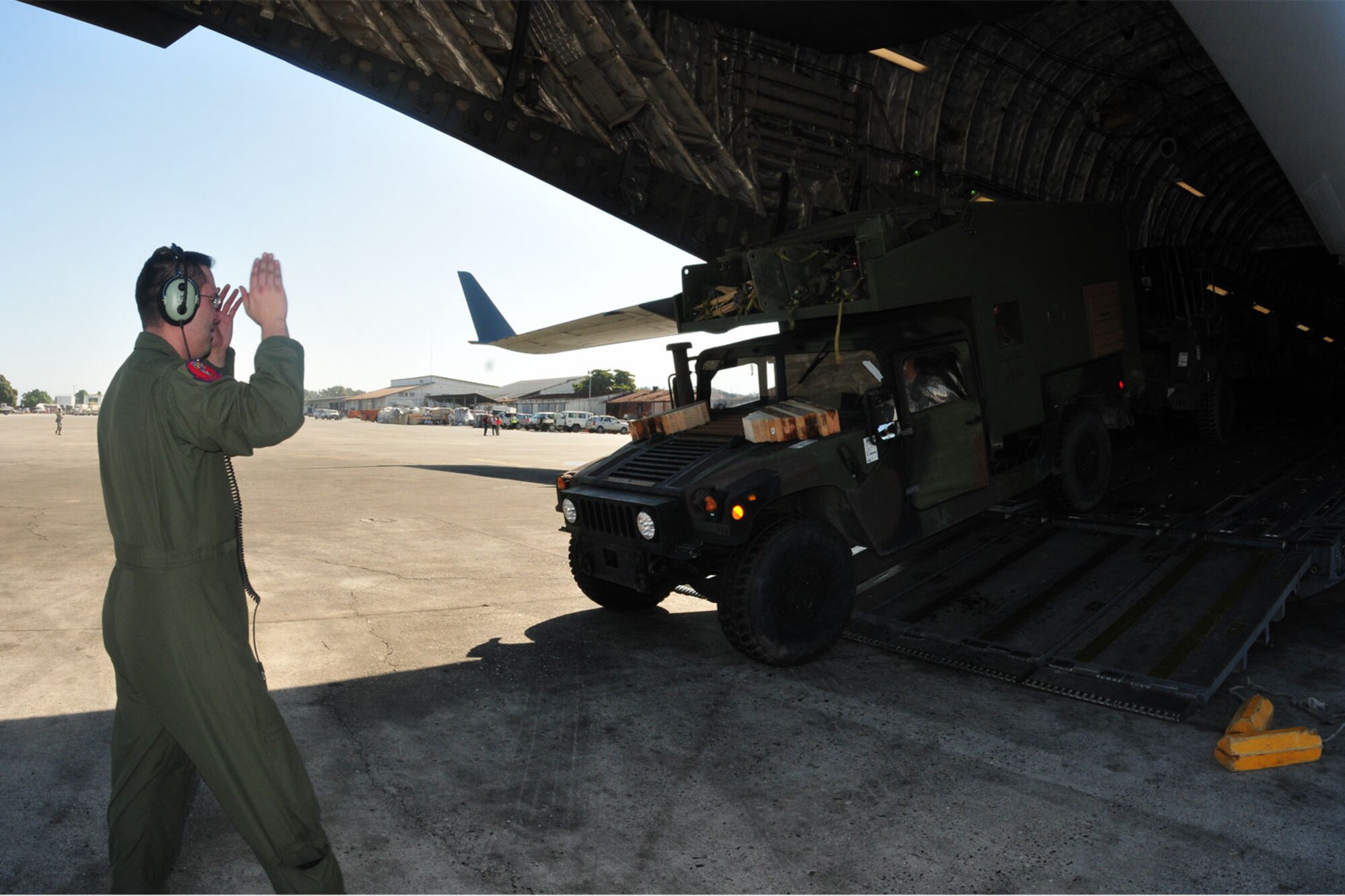 Port au Prince, Haiti – Parked at the Toussaint Louverture International Airport in Port au Prince, Haiti, Tech. Sergeant Piper guides a humvee from Fort Bragg, N.C., out of an Altus AFB, Okla., C-17 Globemaster III Jan. 18. Altus has 10 aircrew teams and six aircraft deployed to Pope AFB, N.C., providing humanitarian relief to Haiti in support of Operation Unified Response. (U.S. Air Force photo/Senior Airman Amanda Bower)
