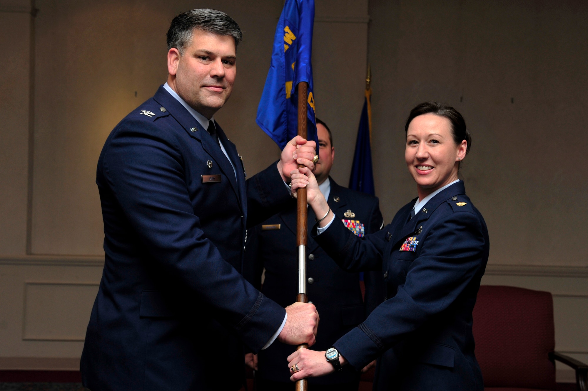 Col. Greg Otey, 19th Airlift Wing commander, hands the command guidon of the 19th Comptroller Squadron to Maj. Tammy Culley, 19th CPTS commander, during a ceremony held Jan. 15 at the conference center. Maj. Culley assumed command of the 19th CPTS after former commander Maj. James Culpepper relinquished command.