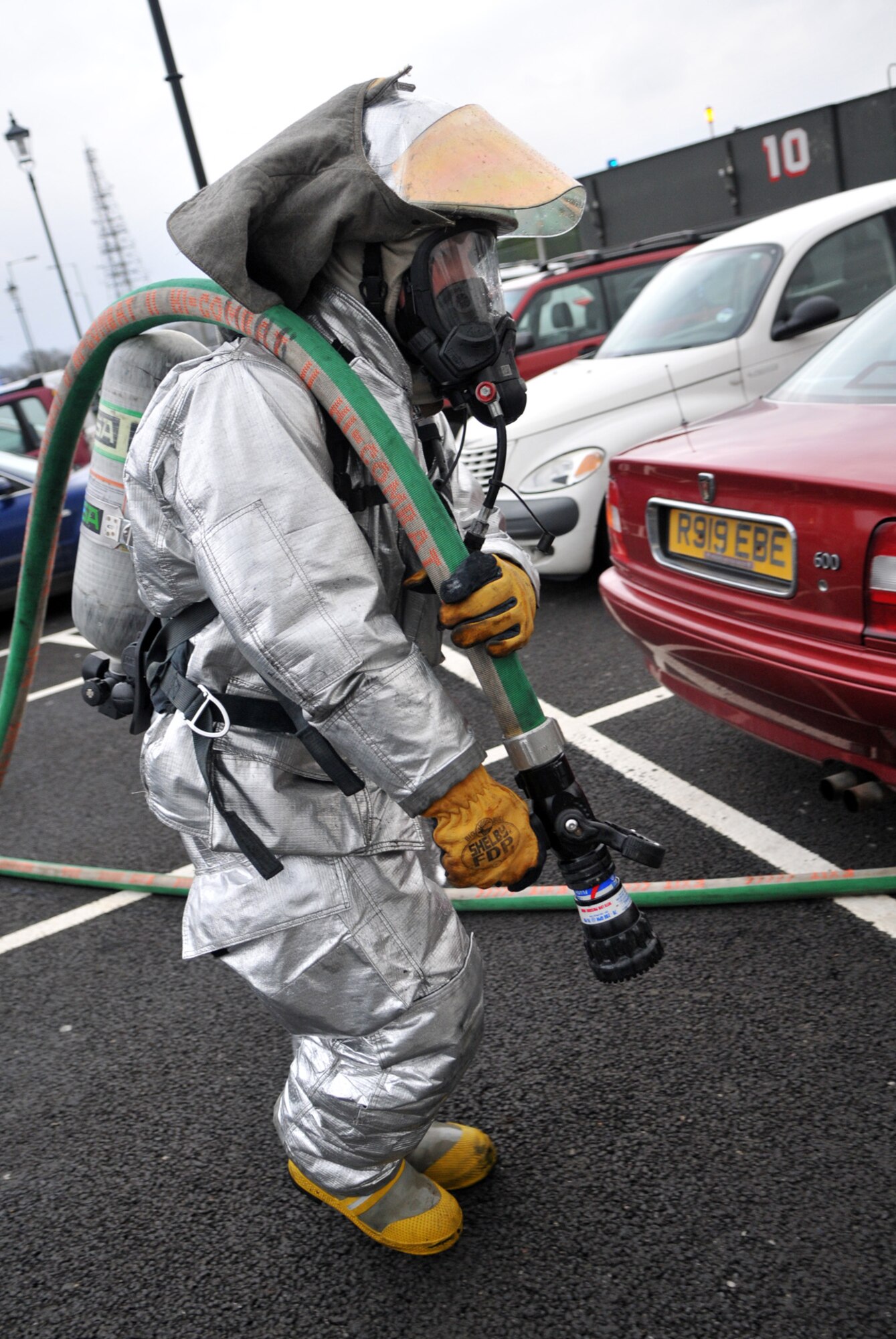RAF MILDENHALL, England -- A base firefighter carries a hose back to the fire truck he pulled it from while responding to a vehicle fire Jan. 20.  No one was injured in the fire.  (U.S. Air Force photo by Staff Sgt. Austin M. May)