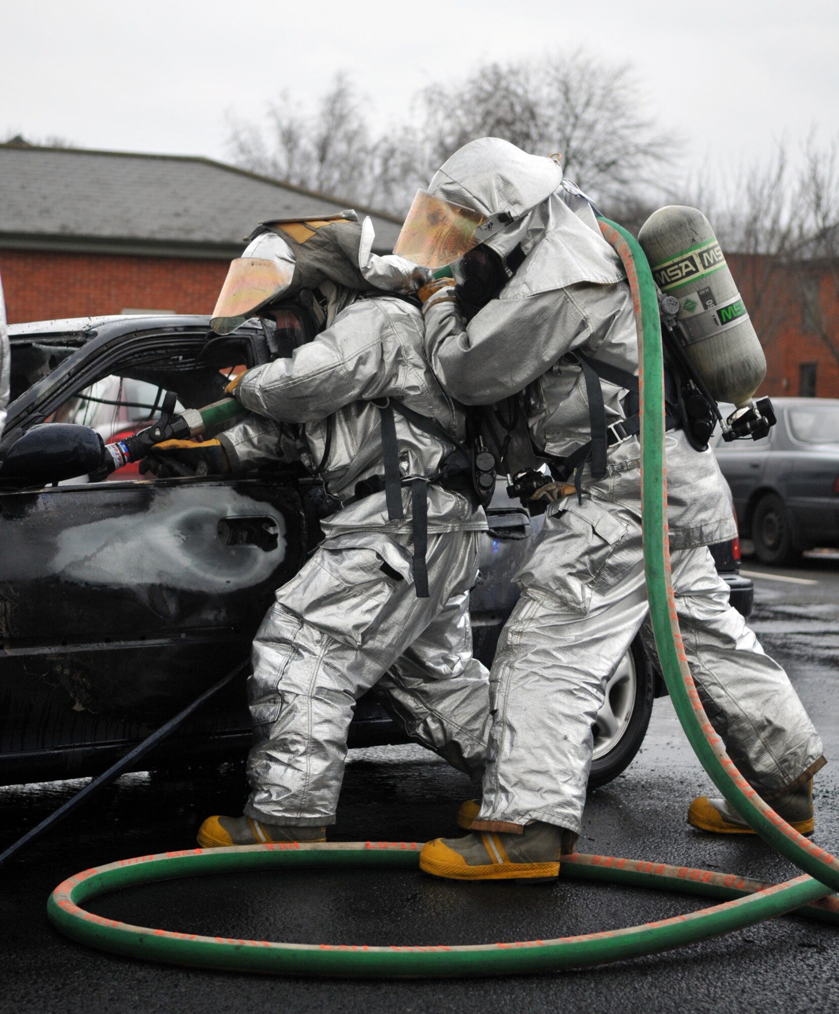 RAF MILDENHALL, England -- Firefighters spray a burned-out car to extinguish any hots spots after fire consumed the vehicle Jan. 20.  The driver escaped unharmed, and firefighters responded in time to prevent any damage to nearby vehicles.  (U.S. Air Force photo by Staff Sgt. Austin M. May)