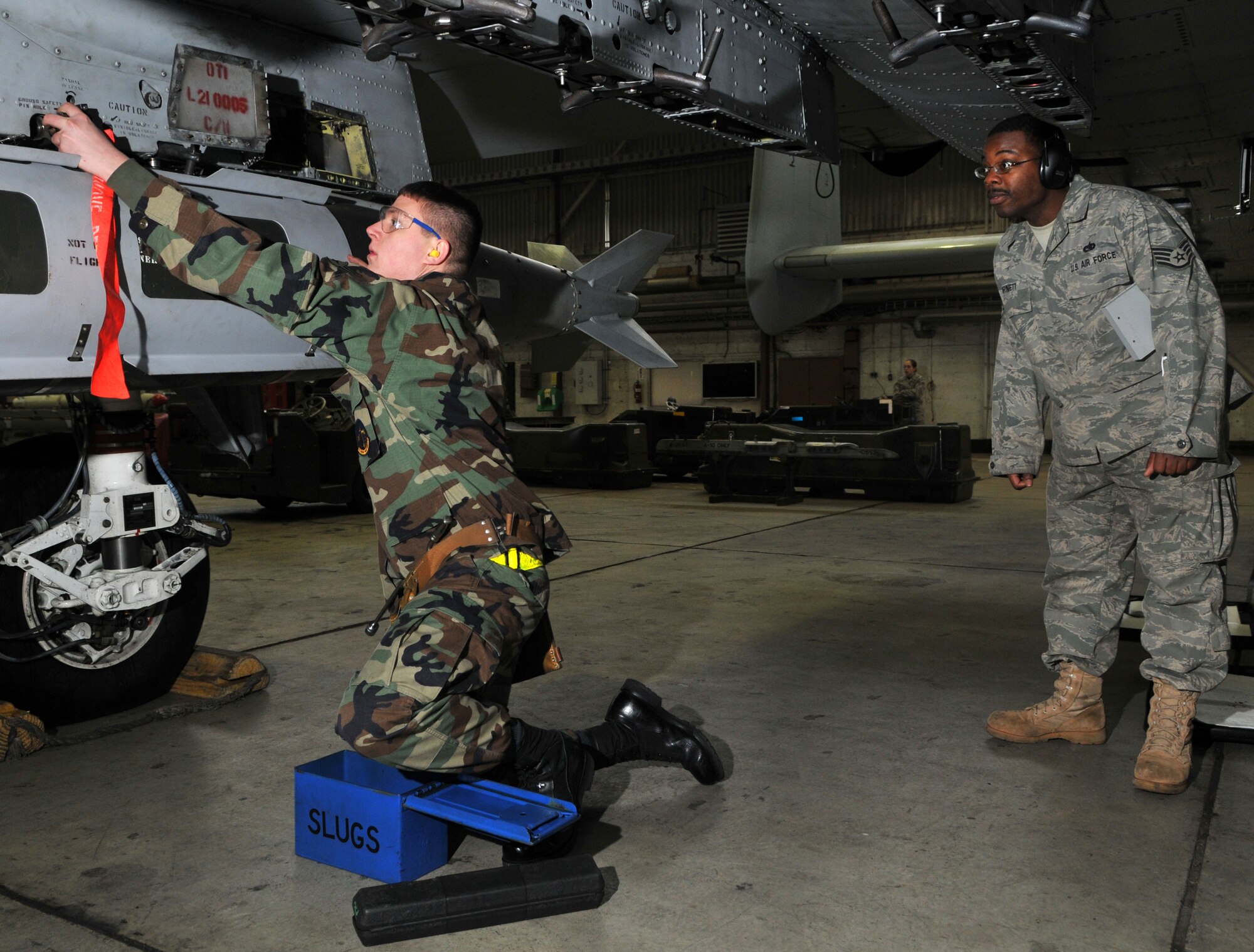 SPANGDAHLEM AIR BASE, Germany -- Airman 1st Class Nathan Scott, 52nd Aircraft Maintenance Squadron, installs impulse cartridges into an F-16 Fighting Falcon bomb rack as Staff Sgt. Ted Burnett, 52nd AMXS, inspects during the 52nd Fighter Wing Weapons Load Crew of the Year Competition Jan. 15. Impulse cartridges are required to release the bomb in flight. . The 52 FW LCOY competition placed load crews from 2009's Weapons Load Crew of the Quarter competitions against each other to crown the weapons load crew of the year and consisted of a dress and appearance and composite tool-box inspection. The competition is still in action, and the winner has not yet been announced as the second quarter weapons load crew winning team is deployed. The contenders in the competition are from the 22nd, 23rd and 81st Aircraft Maintenance Units, and the winner will be announced Feb. 27 at the 52nd Maintenance Group Annual Awards Banquet. (U.S. Air Force photo/Airman 1st Class Nick Wilson)