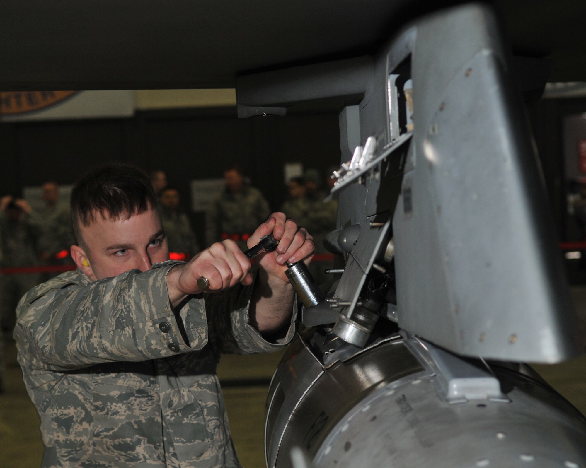 SPANGDAHLEM AIR BASE, Germany -- Airman 1st Class Travis Brown, 52nd Aircraft Maintenance Squadron, engages bomb rack locknuts during the 52nd Fighter Wing Weapons Load Crew of the Year Competition Jan. 15. Locknuts prevent loosening of the bomb in flight. . The 52 FW LCOY competition placed load crews from 2009's Weapons Load Crew of the Quarter competitions against each other to crown the weapons load crew of the year and consisted of a dress and appearance and composite tool-box inspection. The competition is still in action, and the winner has not yet been announced as the second quarter weapons load crew winning team is deployed. The contenders in the competition are from the 22nd, 23rd and 81st Aircraft Maintenance Units, and the winner will be announced Feb. 27 at the 52nd Maintenance Group Annual Awards Banquet. (U.S. Air Force photo/Airman 1st Class Nick Wilson)