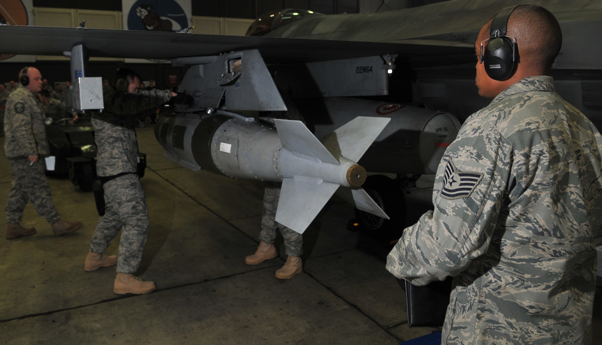 SPANGDAHLEM AIR BASE, Germany -- Tech. Sgt. John Easley, 52nd Aircraft Maintenance Squadron, watches Airman 1st Class Travis Brown and Staff Sgt. David Yokom, 52nd AMXS, perform a simultaneous sway on munitions for an F-16 Fighting Falcon bomb rack assembly during the 52nd Fighter Wing Weapons Load Crew of the Year Competition Jan. 15. Simultaneous swaying of the munitions prevents bomb movement in flight. . The 52 FW LCOY competition placed load crews from 2009's Weapons Load Crew of the Quarter competitions against each other to crown the weapons load crew of the year and consisted of a dress and appearance and composite tool-box inspection. The competition is still in action, and the winner has not yet been announced as the second quarter weapons load crew winning team is deployed. The contenders in the competition are from the 22nd, 23rd and 81st Aircraft Maintenance Units, and the winner will be announced Feb. 27 at the 52nd Maintenance Group Annual Awards Banquet. (U.S. Air Force photo/Airman 1st Class Nick Wilson)