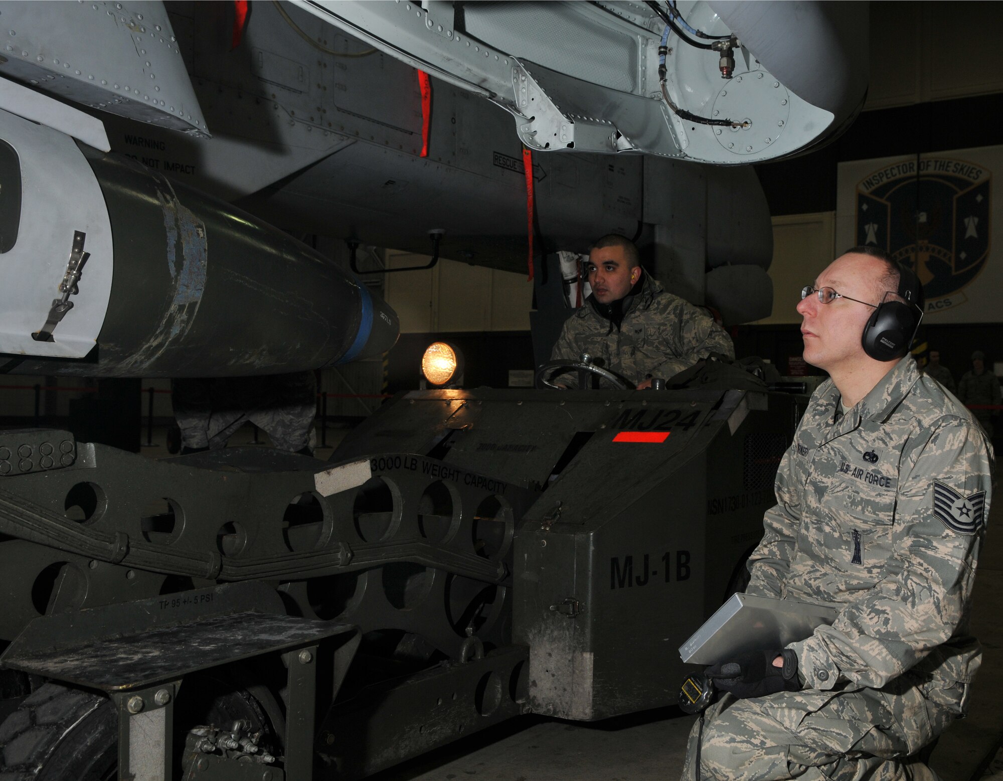 SPANGDAHLEM AIR BASE, Germany -- Senior Airman Thomas Hanes, 52nd Aircraft Maintenance Squadron, positions a 2,000-pound joint direct attack munition for loading as Tech. Sgt. Maichael Giarnieri, 52nd AMXS, watches during the 52nd Fighter Wing Weapons Load Crew of the Year Competition Jan. 15 in Hangar 1. Accurate bomb positioning increases the speed of the load. The 52 FW LCOY competition placed load crews from 2009's Weapons Load Crew of the Quarter competitions against each other to crown the weapons load crew of the year and consisted of a dress and appearance and composite tool-box inspection. The competition is still in action, and the winner has not yet been announced as the second quarter weapons load crew winning team is deployed. The contenders in the competition are from the 22nd, 23rd and 81st Aircraft Maintenance Units, and the winner will be announced Feb. 27 at the 52nd Maintenance Group Annual Awards Banquet. (U.S. Air Force photo/Airman 1st Class Nick Wilson)
