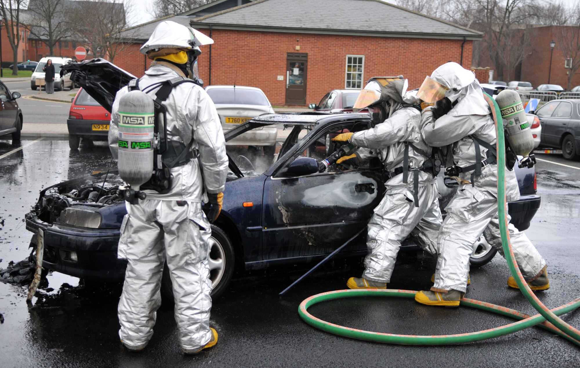 RAF MILDENHALL, England -- Firefighters spray water on the smoldering remains of a car that caught fire in a parking lot on base Jan. 20.  Emergency crews responded in about two minutes, extinguishing the blaze and preventing damage to other vehicles nearby.  No one was injured in the fire, the cause of which is under investigation.  (U.S. Air Force photo by Staff Sgt. Austin M. May)