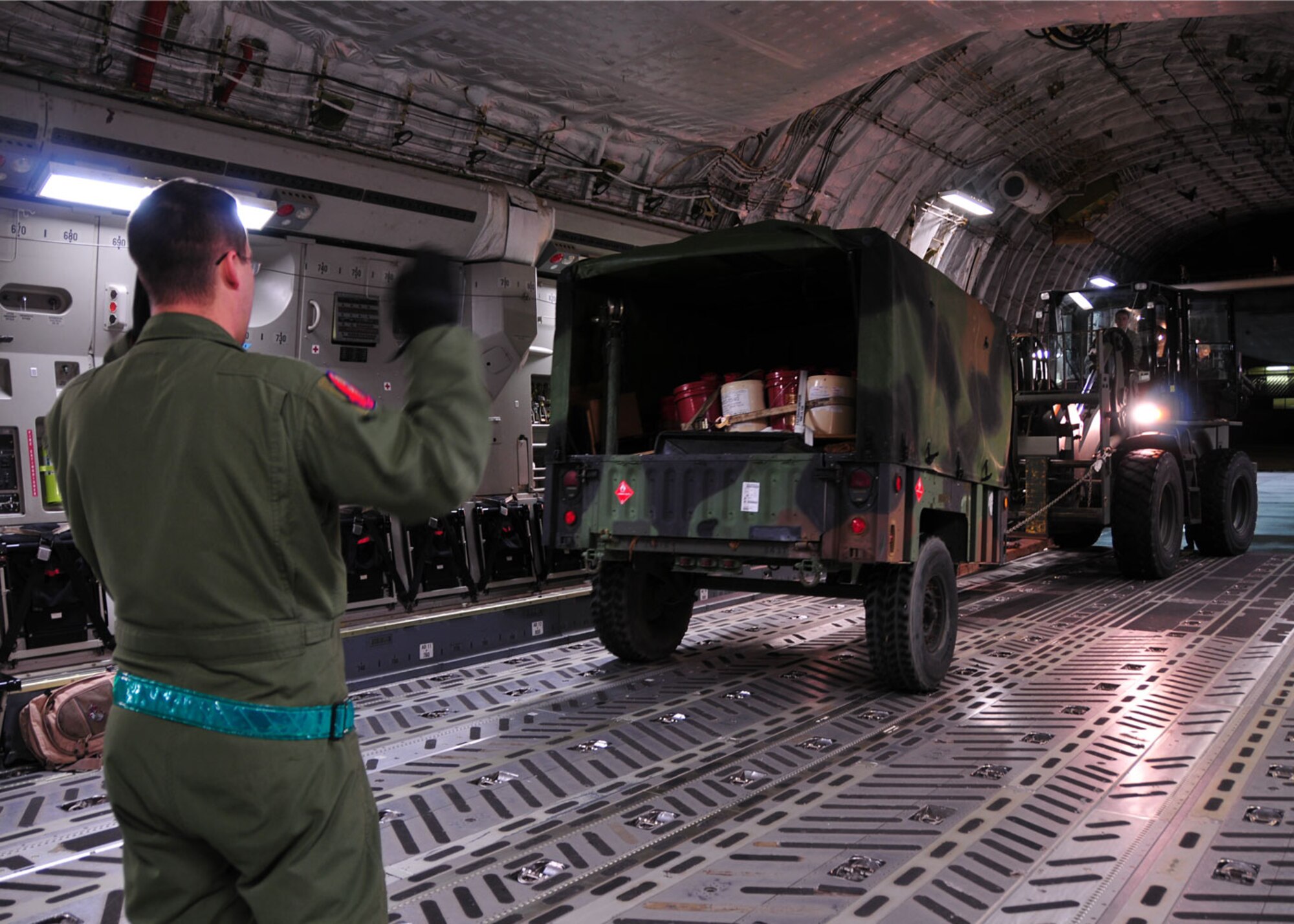 Pope Air Force Base, N.C. – Guiding a forklift pushing a trailer, Tech. Sgt. Joshua, Piper from the 58th Airlift Squadron at Altus AFB, Okla.,  loads an Altus C-17 Globemaster III with Army vehicles and personnel heading to Haiti Jan.18. Ten Altus C-17 aircrew teams are conducting forward operations out of Pope AFB in support Operation Unified Response, a humanitarian mission to provide relief to Haiti. Haiti was struck by an earthquake Jan. 12. (U.S. Air Force photo/Senior Airman Amanda Bower)
