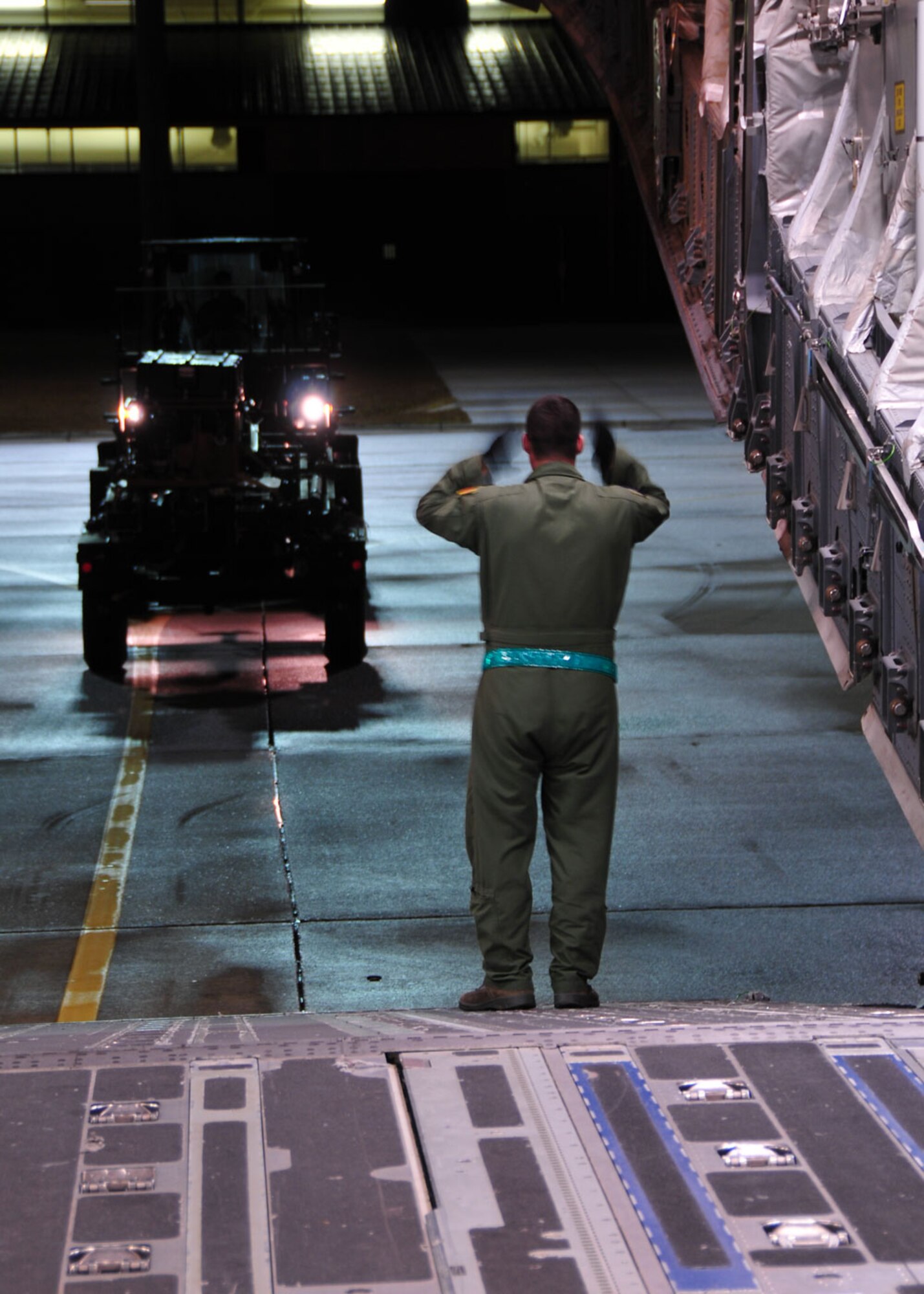 Pope Air Force Base, N.C. – Tech. Sgt. Joshua Piper, from the 58th Airlift Squadron at Altus AFB, Okla., guides an Army vehicle onto an Altus C-17 Globemaster III Jan.18. The C-17 transported Army vehicles and personnel to the Toussaint Louverture International Airport in Port au Prince, Haiti. (U.S. Air Force photo/Senior Airman Amanda Bower)