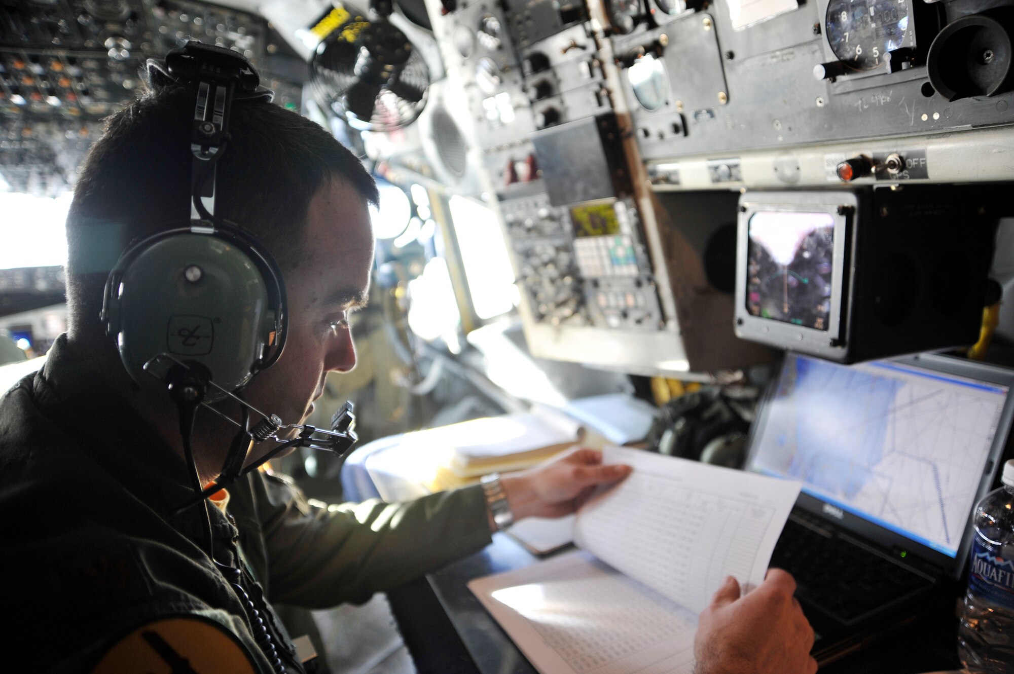 Maj. Michael Vanone reviews the flight plan aboard an OC-135B Open Skies  aircraft Jan 16, 2010, over Haiti. Army, Navy and Air Force personnel used the capabilities of the OC-135B to photograph Haiti, to get a better understanding of the devastation from the earthquake that hit the island Jan. 12. Major Vanone is a navigator with the 45th Reconnaissance Squadron. The OC-135B is with the 45th Reconnaissance Squadron, Offutt AFB, Neb. (U.S. Air Force photo/Airman 1st Class Perry Aston) 
