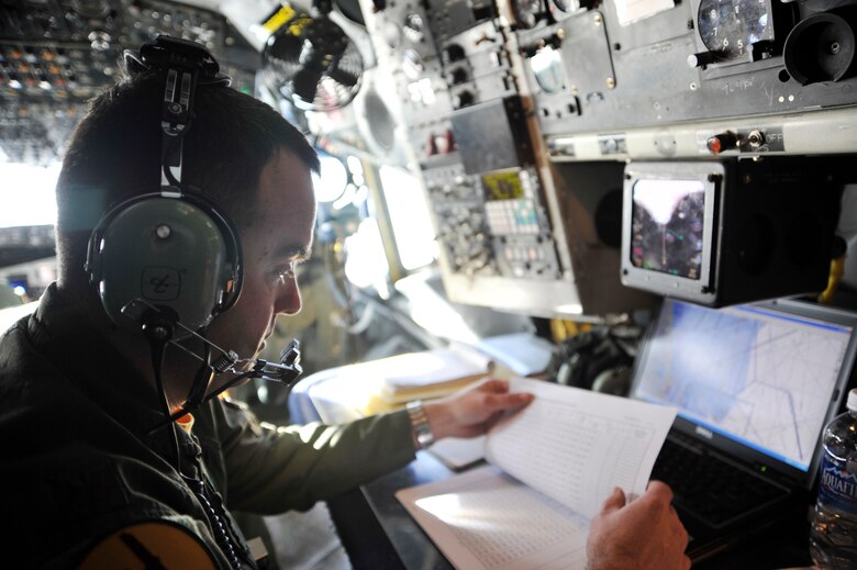 Maj. Michael Vanone reviews the flight plan aboard an OC-135B Open Skies  aircraft Jan 16, 2010, over Haiti. Army, Navy and Air Force personnel used the capabilities of the OC-135B to photograph Haiti, to get a better understanding of the devastation from the earthquake that hit the island Jan. 12. Major Vanone is a navigator with the 45th Reconnaissance Squadron. The OC-135B is with the 45th Reconnaissance Squadron, Offutt AFB, Neb. (U.S. Air Force photo/Airman 1st Class Perry Aston) 
