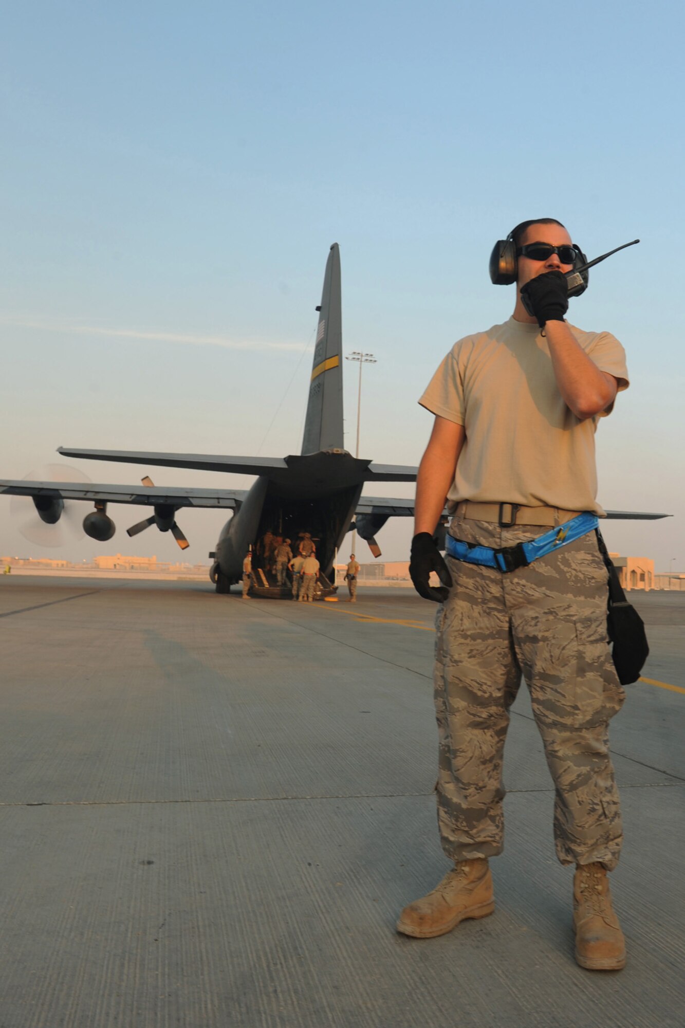 Senior Airman Stephen Wise, 8th Expeditionary Air Mobility Squadron aerial porter, prepares for an "engine running" on- and off-load of passengers and baggage from a C-130 transport plane at a non-disclosed Southwest Asia location, Jan. 18, 2010. (U.S. Air Force photo byTech. Sgt. Michelle Larche)