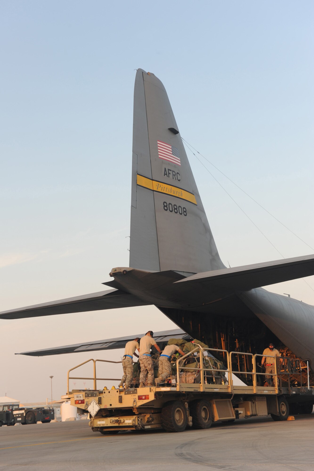 8th Expediitionary Air Mobility Squadron aerial port transporters perform for an "engine running" on- and off-load of passengers and baggage from a C-130 transport plane at a non-disclosed Southwest Asia location, Jan. 18, 2010. (U.S. Air Force photo byTech. Sgt. Michelle Larche)[RELEASED]