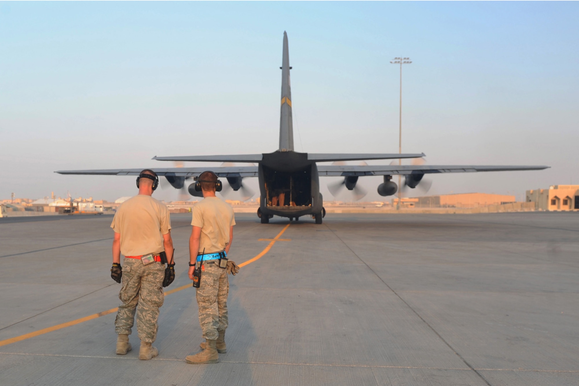 Two 8th Expediitionary Air Mobility Squadron aerial port transporters prepare for an off-load of passengers and baggage from a C-130 transport plane at a non-disclosed Southwest Asia location, Jan. 18, 2010. (U.S. Air Force photo byTech. Sgt. Michelle Larche)