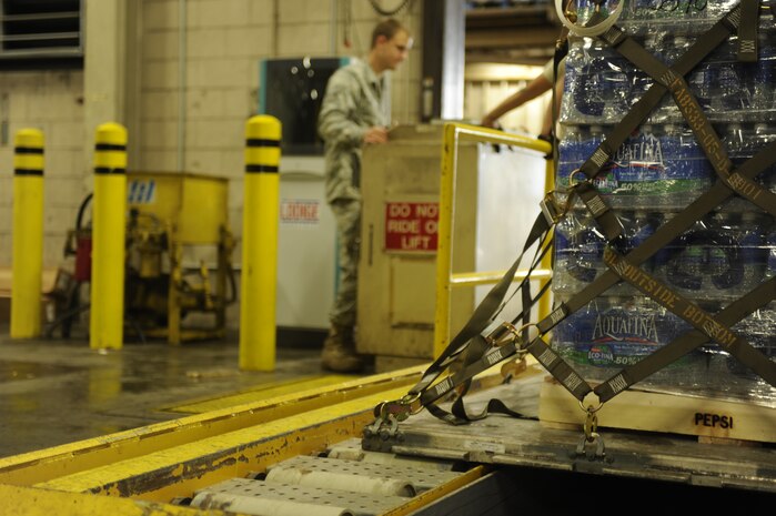 U.S. Air Force Senior Airman Jason Ray, from the 437th Aerial Port Squadron, positions a pallet of water for easy loading at Charleston Air Force Base, S.C, Jan. 17, 2010, during Haiti earthquake relief efforts. 56 pallets of water have been built and will be flown aboard a C-17 Globemaster III aircraft to aid in the relief effort after an earthquake struck Haiti Jan. 12, 2010. Charleston Air Force Base is a component of Air Mobility Command, which has delivered more than 323 tons of emergency cargo to Haiti since relief operations began Jan. 13, 2010. (U.S. Air Force photo by Senior Airman Amber Grimm/Released)