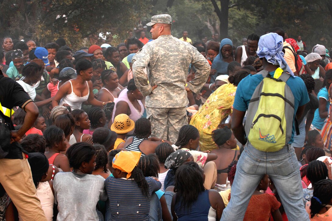 U.S. Army Capt. Jon Hartsock stands in a crowd of women waiting for food and water to be distributed in Port-au-Prince, Haiti, Jan. 19, 2010. Hartsock is assigned to the 82nd Airborne's 1st Squadron, 73rd Cavalry Regiment, and runs the day-to-day distribution of humanitarian aid. 