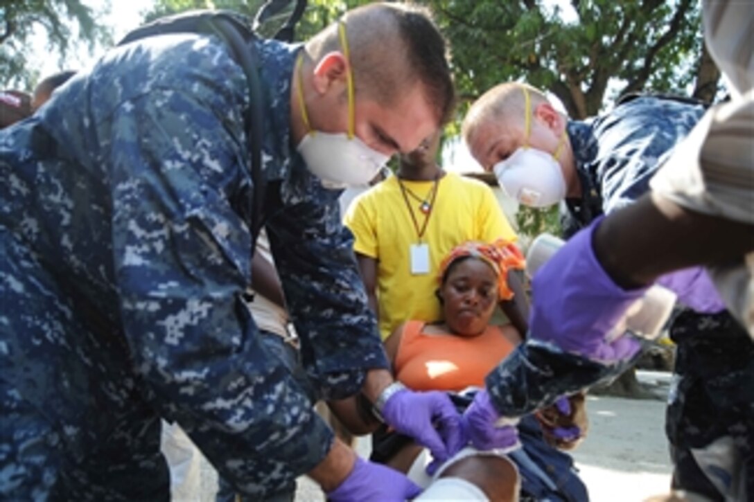 U.S. Navy Lt. Marlin Williams, a chaplain, and Petty Officer 1st Class Adam Kishman, a hospital corpsman, assigned to the aircraft carrier USS Carl Vinson (CVN 70) treat a burn victim at Killick Coast Guard Base in Carrefour, Haiti, on Jan. 18, 2010.  Medical personnel at Killick are giving first aid and primary care treatment in support of hurricane disaster relief.  