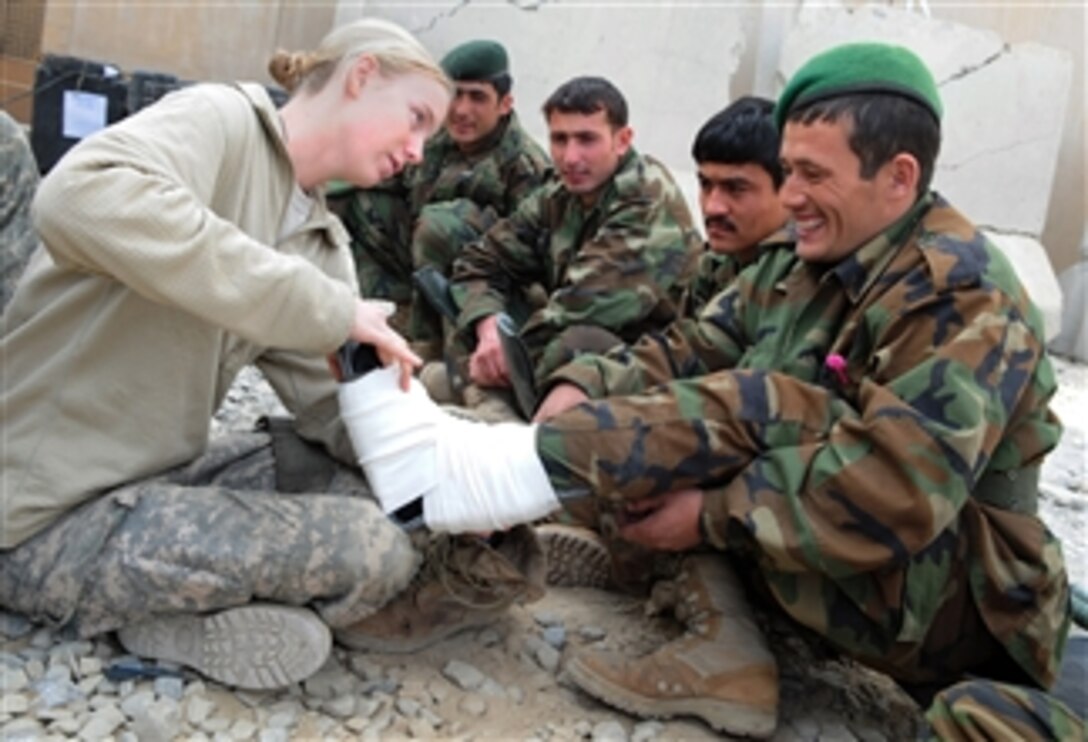 U.S. Army Spc. Jamie Groce, a medic with Headquarters and Headquarters Company, Brigade Special Troops Battalion, 4th Brigade Combat Team, 25th Infantry Division, shows Afghan National Army soldiers how to splint a leg during a combat life saver course at Coalition Outpost Sabari, Afghanistan, on Jan. 16, 2010.  