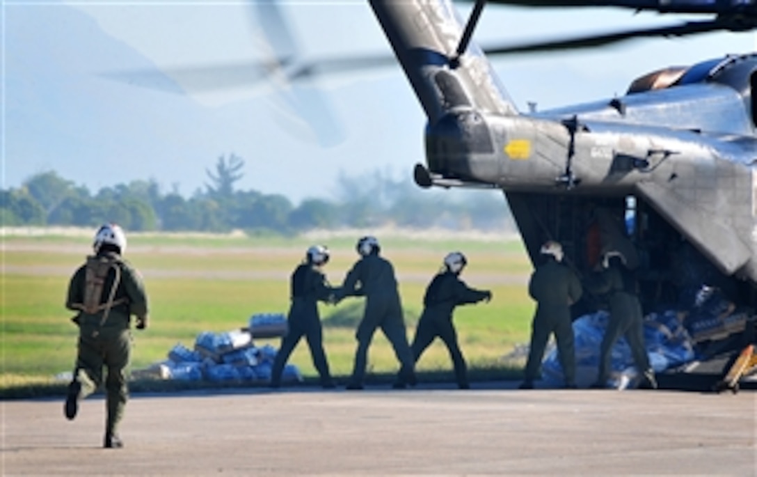 The crew of a U.S. Navy MH-53E Sea Dragon helicopter from the aircraft carrier USS Carl Vinson (CVN 70) unloads food and supplies at the airport in Port-au-Prince, Haiti, on Jan. 15, 2010.  The U.S. military is conducting humanitarian and disaster relief operations after a 7.0 magnitude earthquake caused severe damage near Port-au-Prince on Jan. 12, 2010.  