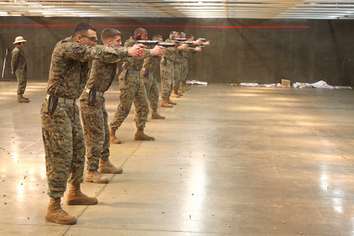 Marines aim at their targets on line during the Wolf-Tactical Reconnaissance and Personal Protection training at the Indoor Small-Arms Range here Jan 21. Jamison Elder, a former recon Marine, designed the pistol training to help service members to be better equipped in today’s combat theaters. Wolf-Tactical Reconnaissance and Personal Protection is better known as WOLF T.R.A.P.P.