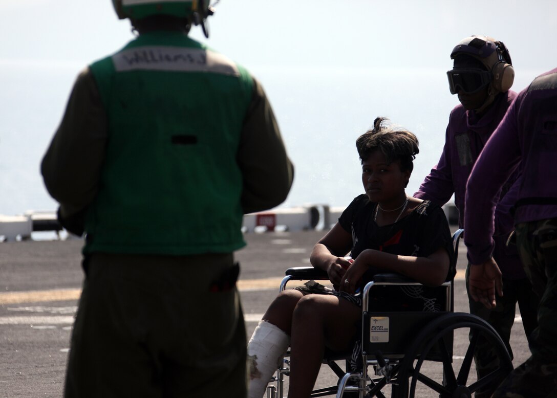 Personnel from the amphibious assault ship USS Bataan move a Haitian earthquake victim from a helicopter to medical facilities, Jan. 20, 2010. The 22nd Marine Expeditionary Unit is embarked aboard the ships of the Bataan Amphibious Ready Group off the island of Haiti to provide humanitarian assistance and disaster relief in the wake of a devastating earthquake that struck the country Jan. 12, 2010.
