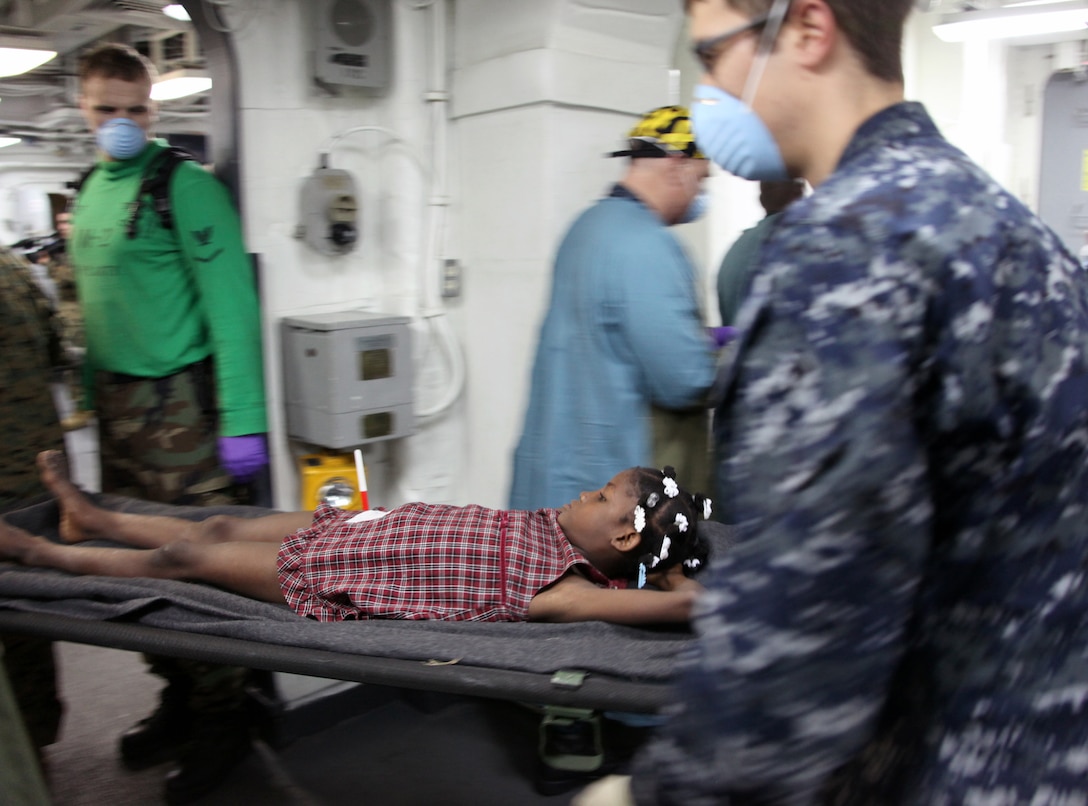 Personnel from the amphibious assault ship USS Bataan move a Haitian earthquake victim from a helicopter to medical facilities, Jan. 20, 2010. The 22nd Marine Expeditionary Unit is embarked aboard the ships of the Bataan Amphibious Ready Group off the island of Haiti to provide humanitarian assistance and disaster relief in the wake of a devastating earthquake that struck the country Jan. 12, 2010.