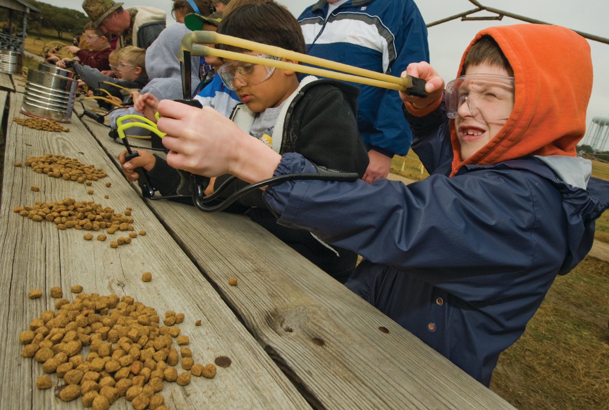 Lining up his slingshot at a target down range, 6-year-old Harrison Bendet uses dog food as ammo. The Cub Scouts used the dog food for safety reasons, not to mention it's biodegradable. (photo by Tech. Sgt. Samuel Bendet)