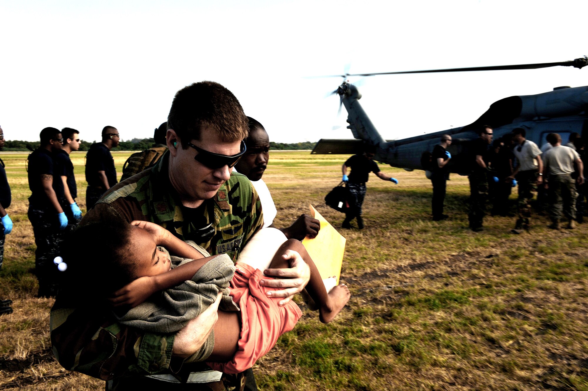 Maj. Timothy Ballard carries a 6- year-old boy from a helicopter to a field clinic Jan 19, 2010, at the Toussaint L'Ouverture International Airport in Port-au-Prince, Haiti. Later, the boy was air lifted to a stateside hospital in southern Florida.  Major Ballard is with the 1st Special Operations Support Squadron at Hurlburt Field, Fla. (U.S. Air Force photo/Tech. Sgt. James L. Harper Jr.) 