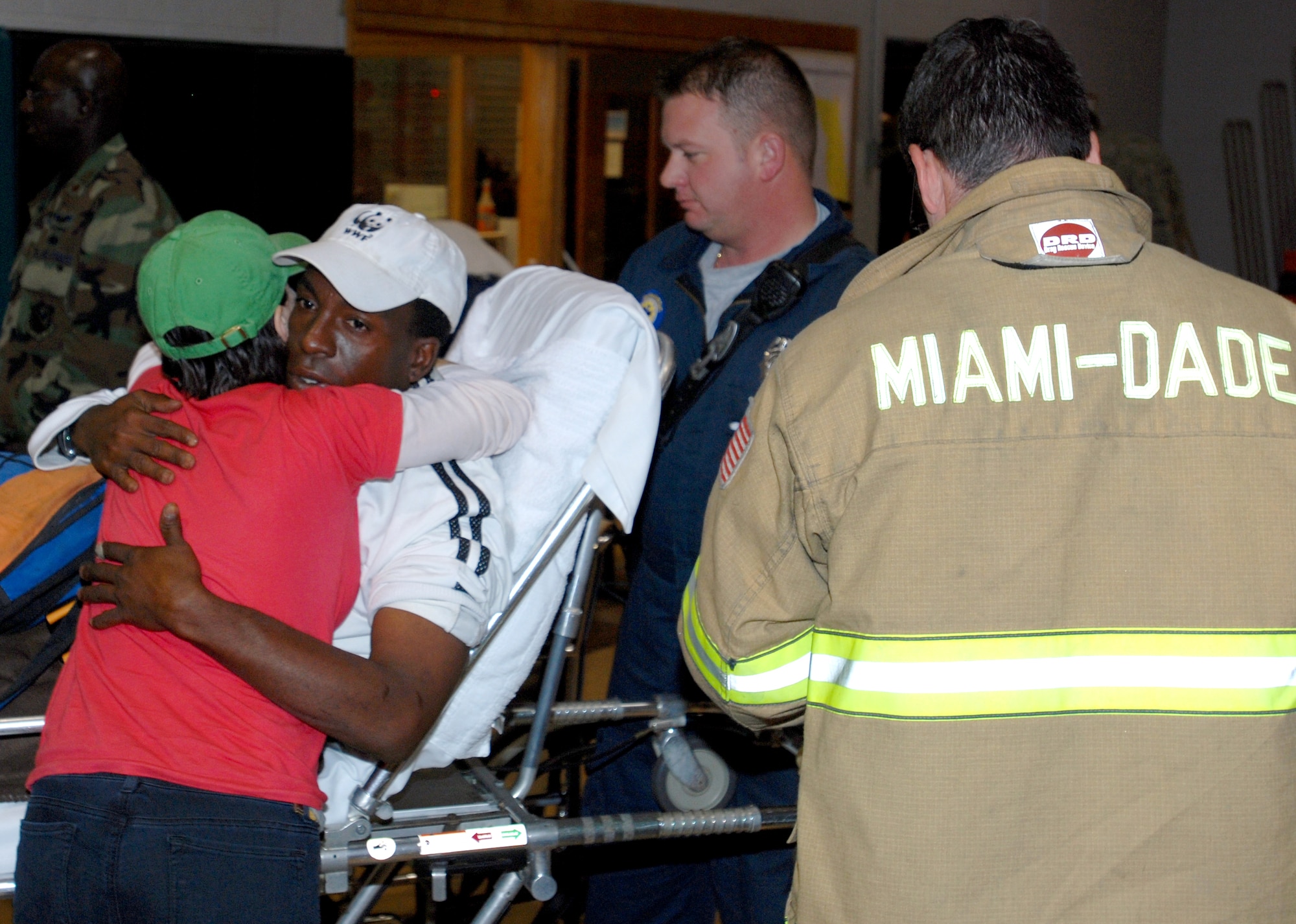 Rachel Florio, a Connecticut native, hugs a Haitian, Jan. 20, 2010, at Homestead Air Reserve Base, Fla., before firefighters from the Miami-Dade Fire Department take him to a local hospital.  The Haitian broke his ankle when he jumped off the roof of a two-story building during the earthquake that devastated the island nation Jan. 12.  (U.S. Air Force photo/Tech. Sgt Brian Bahret)