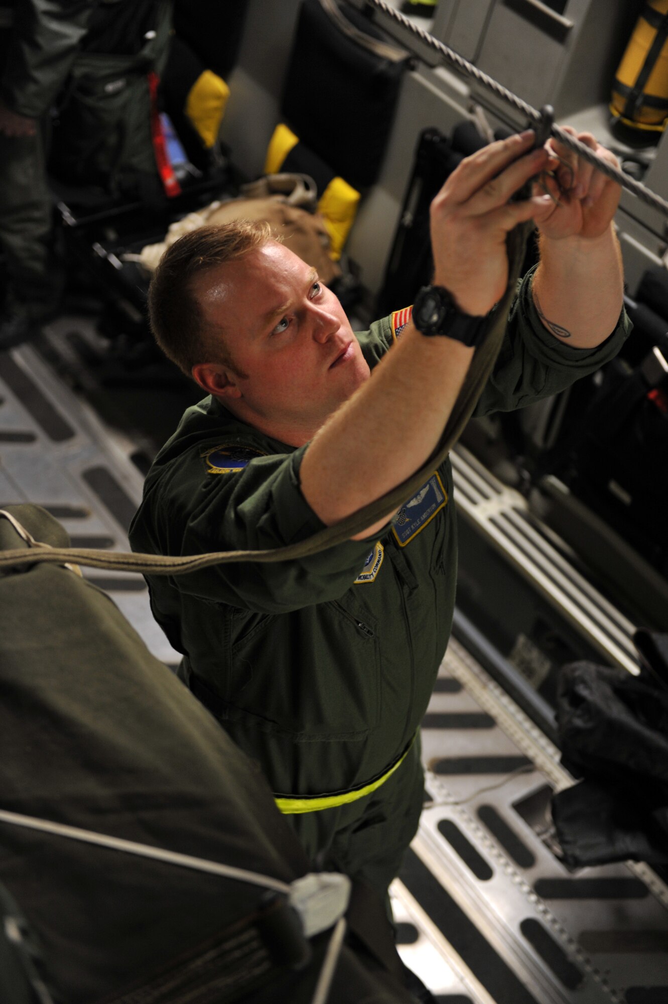 Staff Sgt. Kyle Anderson attaches a pilot chute anchor cable to the static line of a C-17 Globemaster III Jan. 21, 2010, Pope Air Force Base, Fayetteville, N.C. Sgt. Anderson is a loadmaster from the 43rd Operations Support Squadron and is conducting a joint air delivery inspection on humanitarian supply pallets before they are air dropped over Haiti for a relief mission. The C-17, from Charleston Air Force Base, Charleston S.C., will be conducting a humanitarian air delivery mission over Haiti. U.S. Southern Command is deploying assets to Haiti to conduct search and rescue operations, damage assessments, and transitions sustained Humanitarian Assistance/Disaster Relief operations in order to prevent human suffering and additional loss of life. (U.S. Air Force photo/Master Sgt. Shane A. Cuomo)