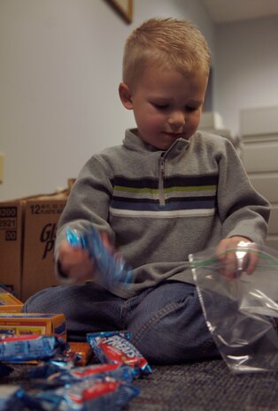 Noah Mcnabb loads snacks into a bag at Charleston AFB Jan. 21. The snack bags are for the evacuees that the C-17?s are bringing out of Haiti after the devastating earthquake. Noah is the son of Capt. Jarrett Mcnabb who is the assistant director of operations with the 437th Operations Support Squadron. (U.S. Air Force photo/Airman 1st Class Lauren Main)
