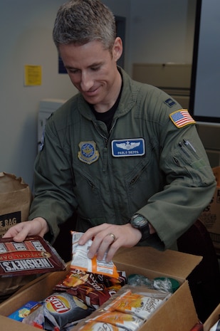 Capt. Pablo Dieppa packs a box of snacks at Charleston AFB, Jan. 21. The snacks are being given to evacuees by C-17 aircrews in support of the humanitarian relief effort. Captain Dieppa is a pilot with the 17th Airlift Squadron. (U.S. Air Force photo/Airman 1st Class Lauren Main)

