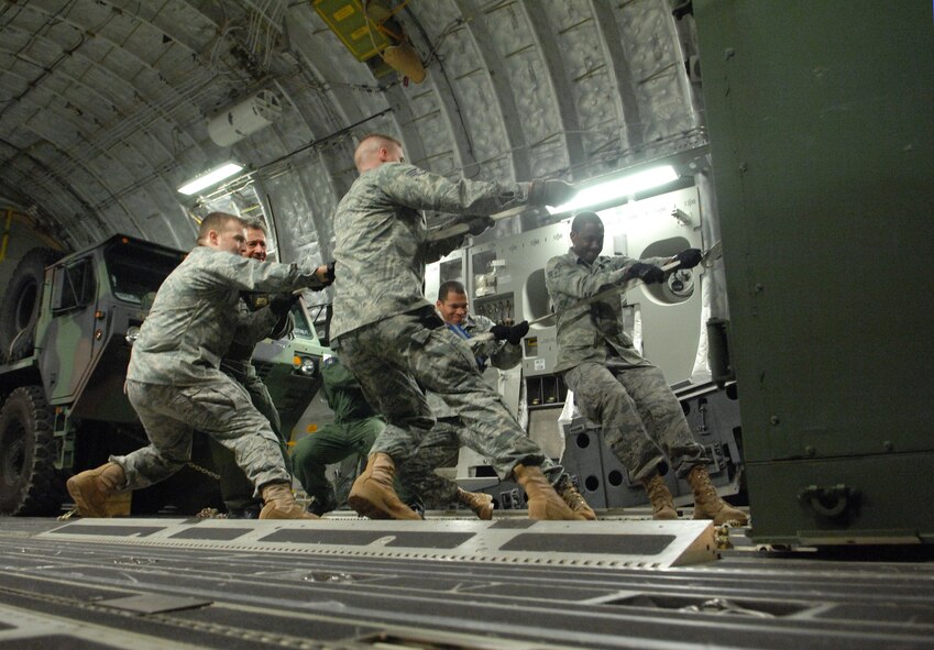 Airmen from the 628th Security Forces Squadron/Raven out of Charleston AFB, work as a team as they assist crew members with the onload of equipment aboard a C-17A Globemaster III from the 729th Airlift Squadron out of March ARB on Saturday, January 16, 2010 which is bound for the Port-au-Prince International Airport, Haiti. The C-17 and crew, both out of the 452nd Air Mobility Wing at March Air Reserve Base, are taking part in the massive international effort to assist in rescue, recovery and humanitarian efforts following a 7.0 earthquake. President Barack Obama ordered a swift and aggressive rescue effort.  The January 12, 2010 quake, centered near the island nation's capital of Port-au-Prince, has left untold numbers of residents homeless, injured or dead.(U.S. Air Force photo by Master Sgt. Dawn Price/released)