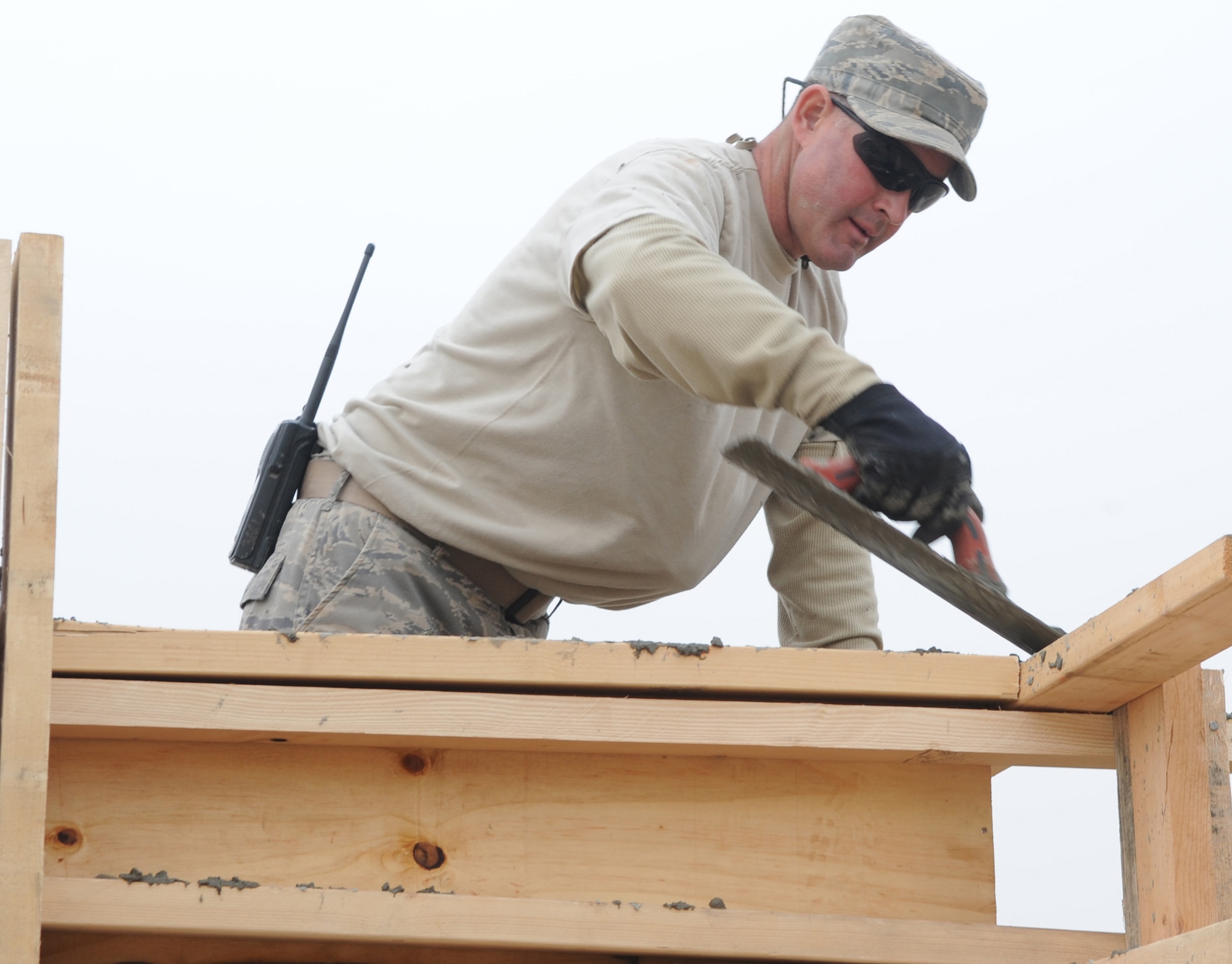 KIRKUK REGIONAL AIR BASE, Iraq., - Tech. Sgt. Dave Powell, 506th Expeditionary Civil Engineering Squadron structures technician, levels off concrete while setting walls Jan. 14. Sergeant Powell is a Reservist deployed from the 446th Civil Engineering Squadron, McChord Air Force Base, Wash. (U.S. Air Force photo/Staff Sgt. Tabitha Kuykendall)