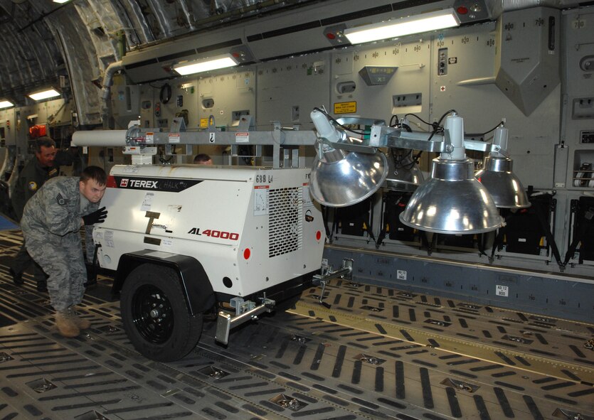 U. S Air Force Senior Master Sgt. William J. Lamela (rear), Load Master for the C-17A Globemaster from the 729th Airlift Squadron, out of March Air Reserve Base, U.S. Air Force Staff Sgt. Christopher Votaw, 628th Security Forces/Raven, out of Charleston, AFB, work together to load a generator Saturday, January 16th, 2010, bound for the Port-au-Prince International Airport, Haiti. The C-17A and crew, both out of the 452nd Air Mobility Wing at March Air Reserve Base, are taking part in the massive international effort to assist in rescue, recover and humanitarian efforts following a 7.0 earthquake. President Barack Obama ordered a swift and aggressive rescue effort.  The January 12, 2010 quake, centered near the island nation's capital of Port-au-Prince, has left untold numbers of residents homeless, injured or dead.(U.S. Air Force photo by Master Sgt. Dawn Price/released)