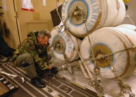 U. S Air Force Senior Master Sgt. William J. Lamela, Load Master for a C-17A Globemaster from the 729th Airlift Squadron, out of March Air Reserve Base, secures a palet of water Friday, January 15th, 2010, bound for Port -au-Prince International Airport, Haiti. The C-17A and crew, both out of the 452nd Air Mobility Wing at March Air Reserve Base, are taking part in the massive international effort to assist in rescue, recover and humanitarian efforts following a 7.0 earthquake. President Barack Obama ordered a swift and aggressive rescue effort.  The January 12, 2010 quake, centered near the island nation's capital of Port-au-Prince, has left untold numbers of residents homeless, injured or dead.(U.S. Air Force photo by Master Sgt. Dawn Price/released)