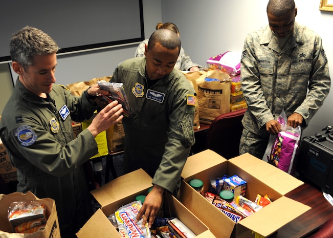 Charleston Airmen load snacks into a box on Charleston AFB, Jan. 21. The snacks were an idea by aircrew members and families, to help feed evacuees as they are brought out of Haiti on C-17?s during the humanitarian relief effort.  (U.S. Air Force photo/Senior Airman Katie Gieratz)(RELEASED) 


