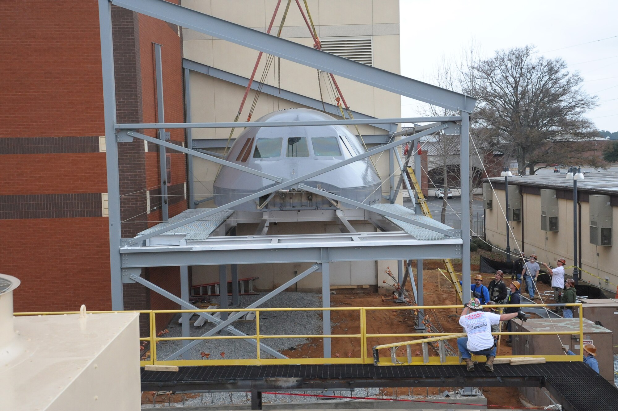 Members of the 402nd Maintenance Support Squadron’s Industrial Services, lift the C-5 cockpit into place at Bldgs. 226 & 230. (U. S. Air Force Photo by Ray Crayton)